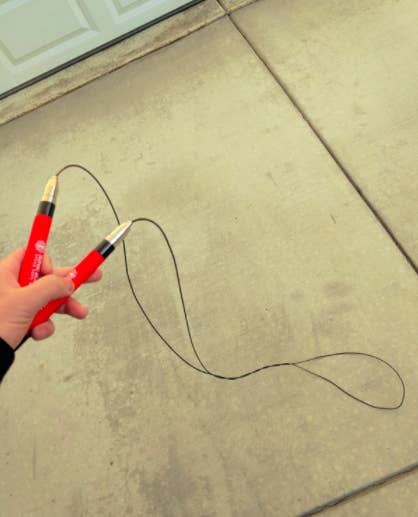 Reviewer holds red jump rope in hands before completing a workout