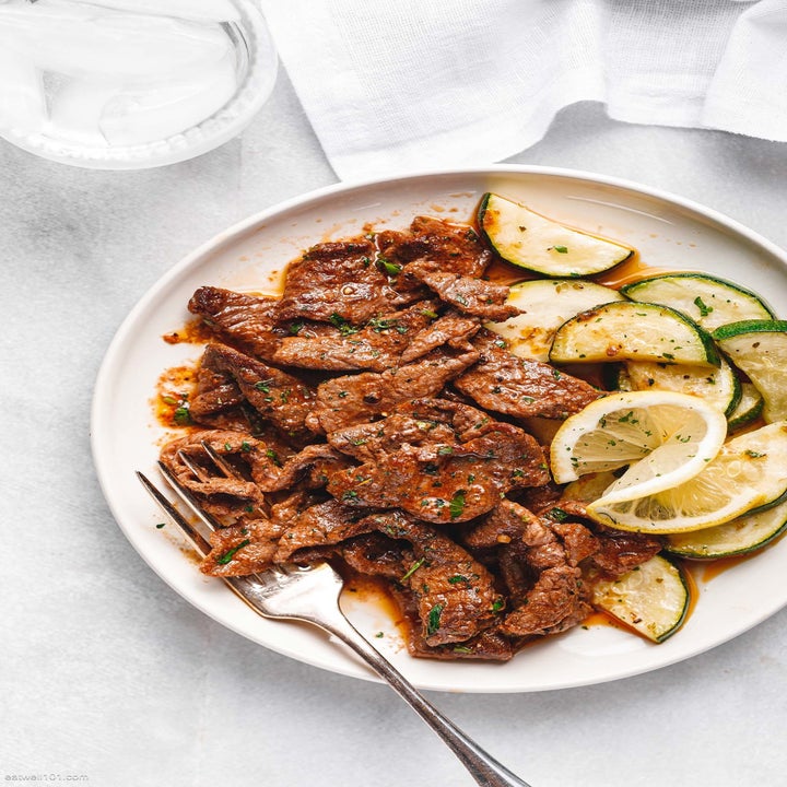 A plate of marinated steak and lemon zucchini.