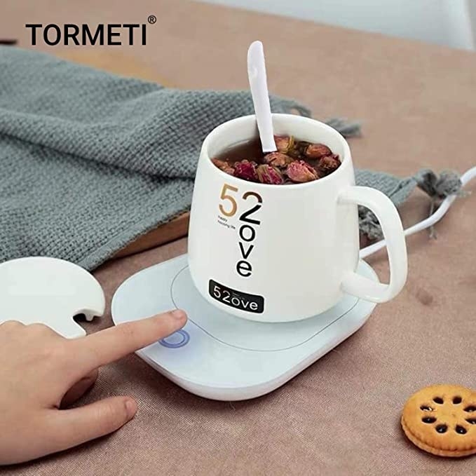 Mug warmer with some tea in it on a table.