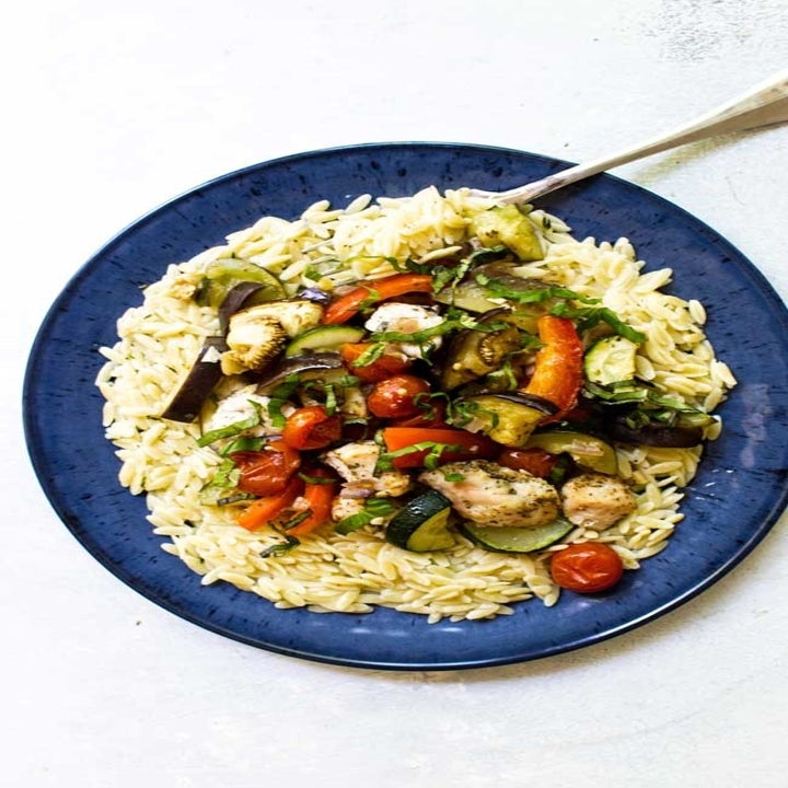 Chicken ratatouille served over a plate of rice.