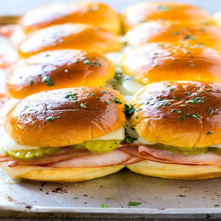 Eight Cuban sliders on a sheet pan.