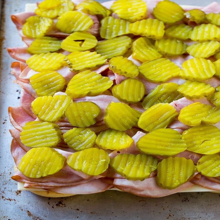 Hawaiian rolls topped with thinly sliced ham and pickles.