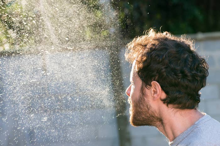 A person sneezing without a mask.