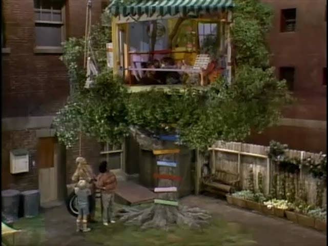 A exterior shot of a tree with Punky&#x27;s colorful tree house on top of it