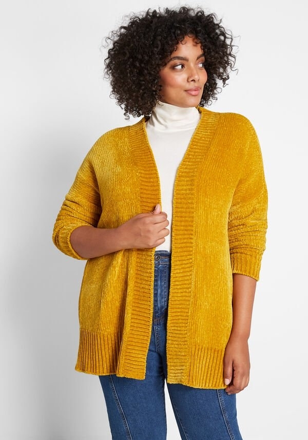 A model wearing the open gold cardigan that hits below the hips