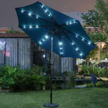 the same umbrella tilted to the side at night to show the solar lights inside