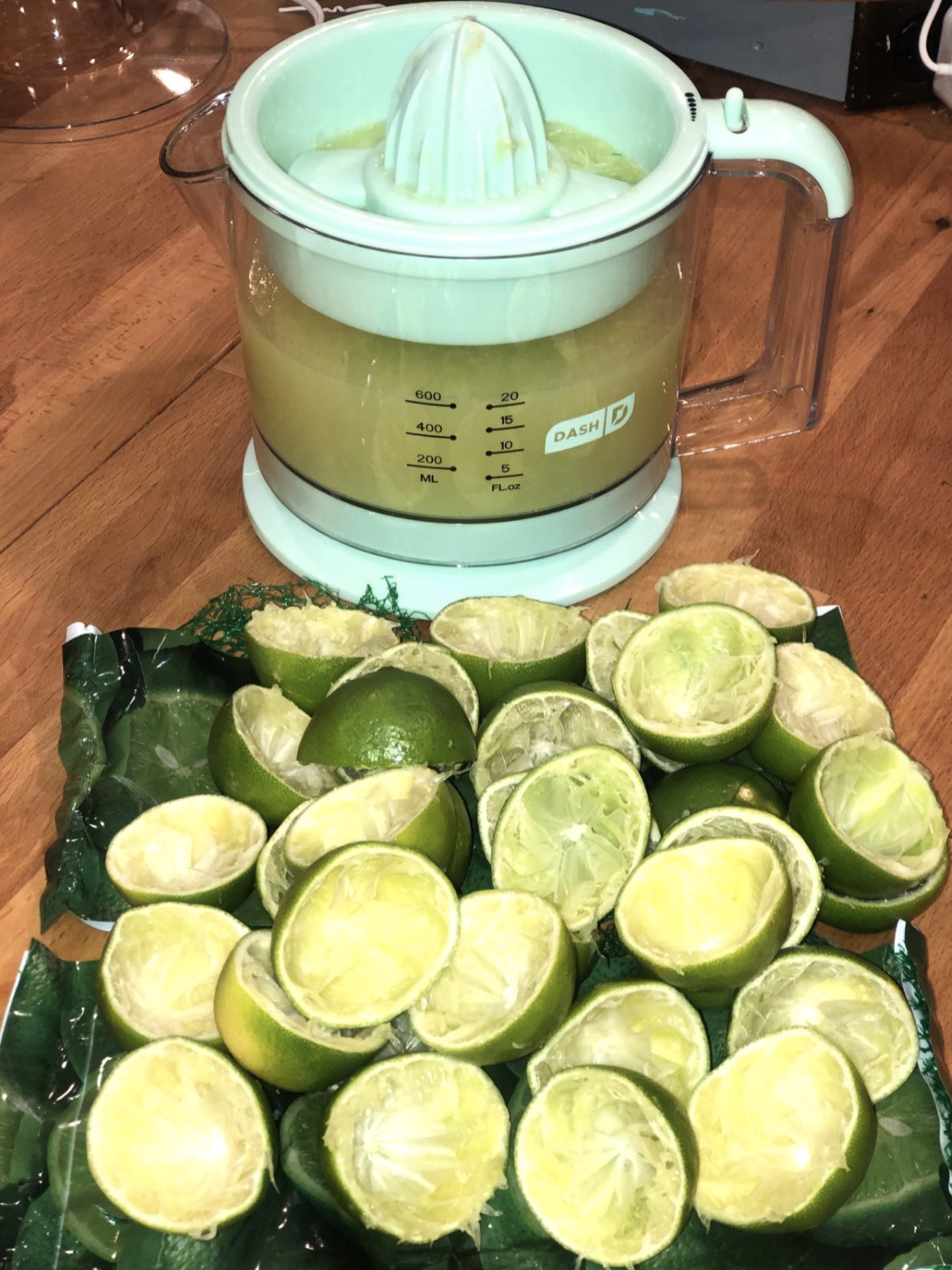 reviewer photo of blue and white juicer with lime juice inside