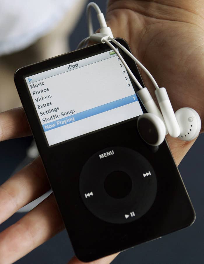 A photo of a hand holding a black iPod Classic