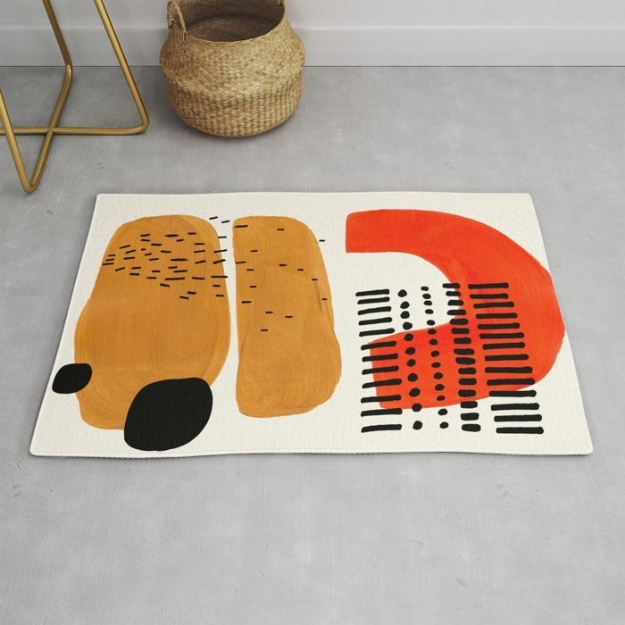 Rug in abstract shapes and white, black, red, and tan