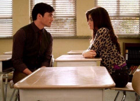 Ezra and Aria stare longingly at each other in a classroom