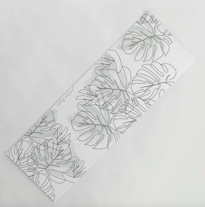 White yoga mat with a gray and black botanical leaf print