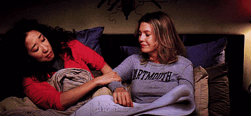 Cristina Yang leans into Meredith Grey&#x27;s side as they lay in bed