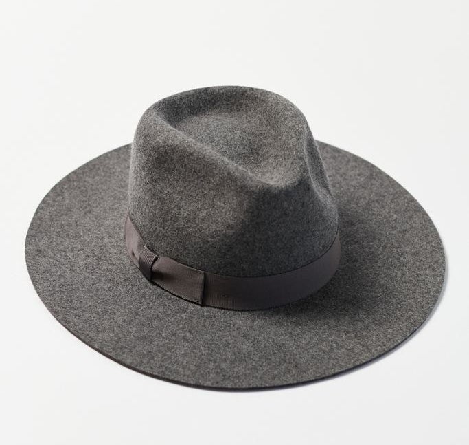 The panama hat or elongated flat-brimmed fedora in gray with a bow around the dimpled crown to hide the adjustable strap 