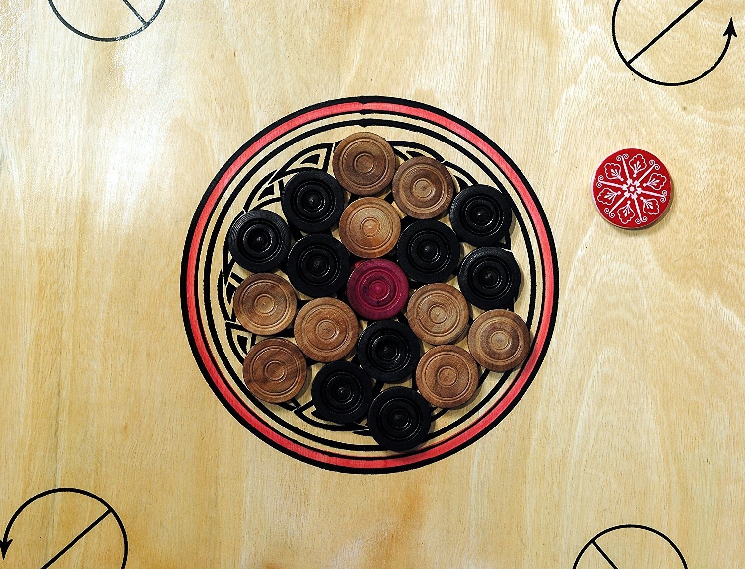 Carrom pieces arranged in the middle of the carrom board.