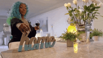 Spice from Love and Hip Hop Atlanta placing a home sign on the countertop 