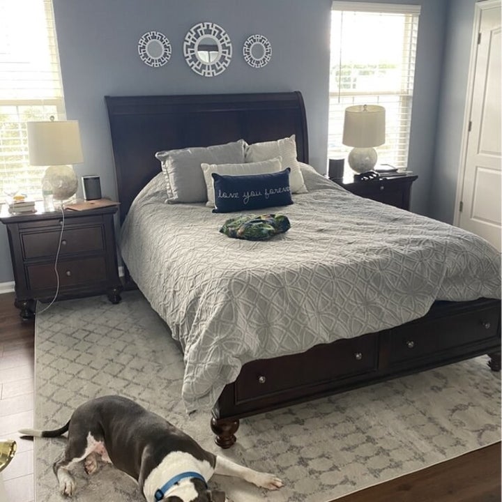Reviewer image of the rug under a bed in beige and grey 