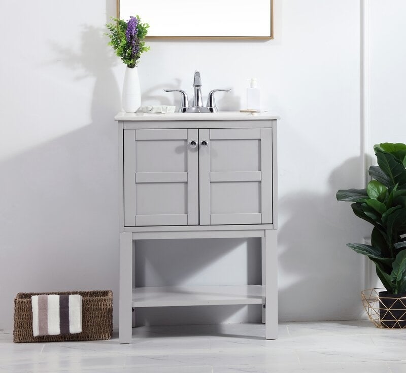 The grey vanity with white counter and a cabinet bottom, plus storage shelf below the cabinet doors