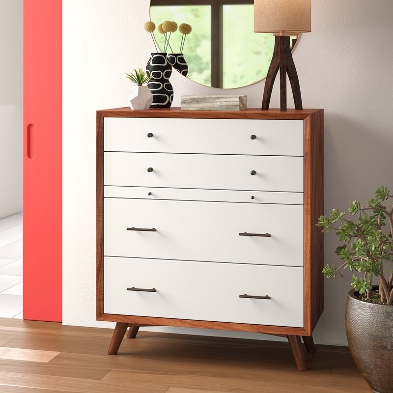 Dresser with a brown frame and legs and white drawer on the front in different sizes.