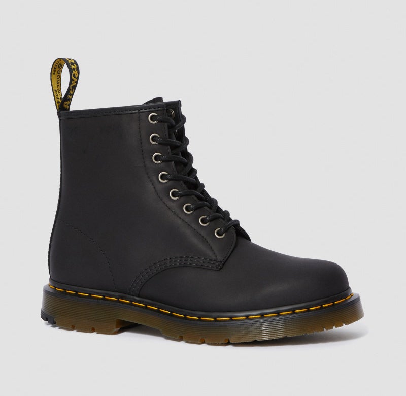 Side view of a black boot with yellow stitched around the rubber sole and AIr Wair pull tab