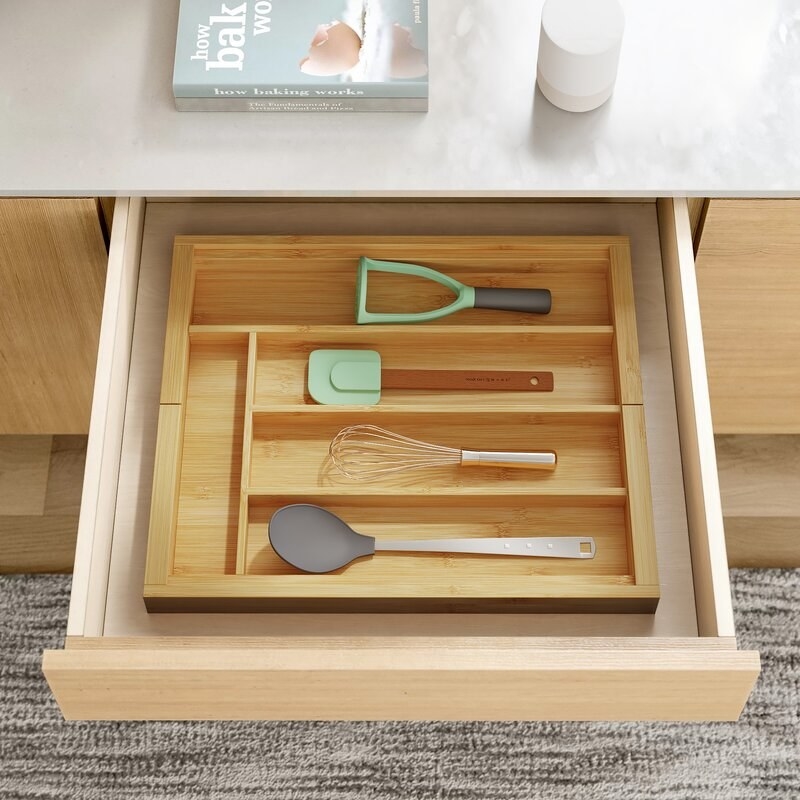 The organizer expanded in a drawer to fit perfectly and organize kitchen utensils 