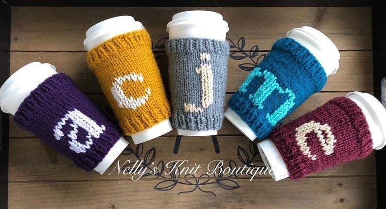 The sleeves on coffee cups in a variety of colors with a letter on each one