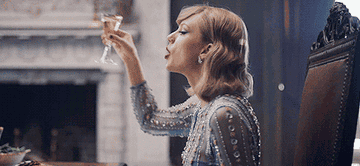 Taylor Swift toasting with a glass of Champagne.