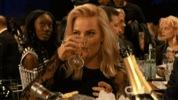Margot Robbie drinking champagne during an Awards Show.
