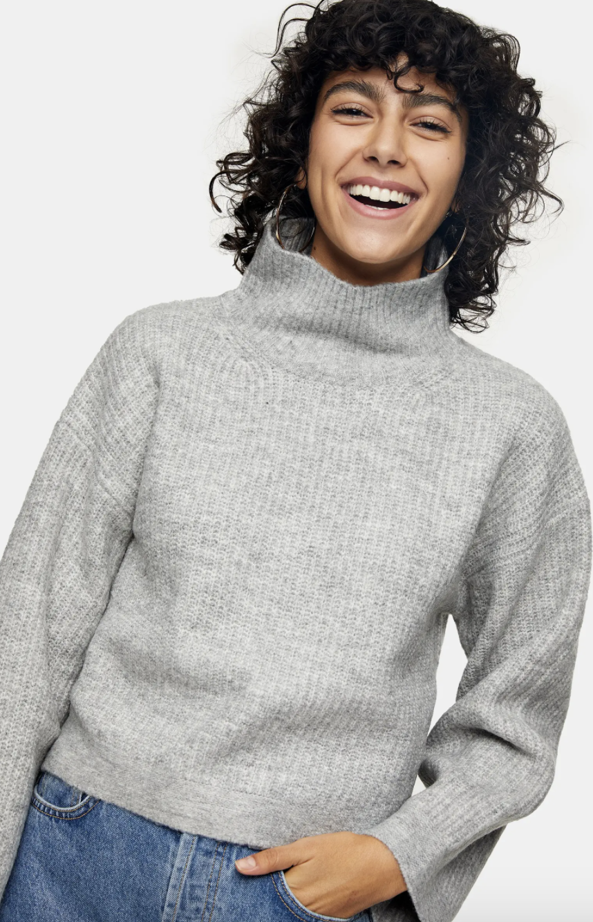 a model in a grey funnel neck sweater