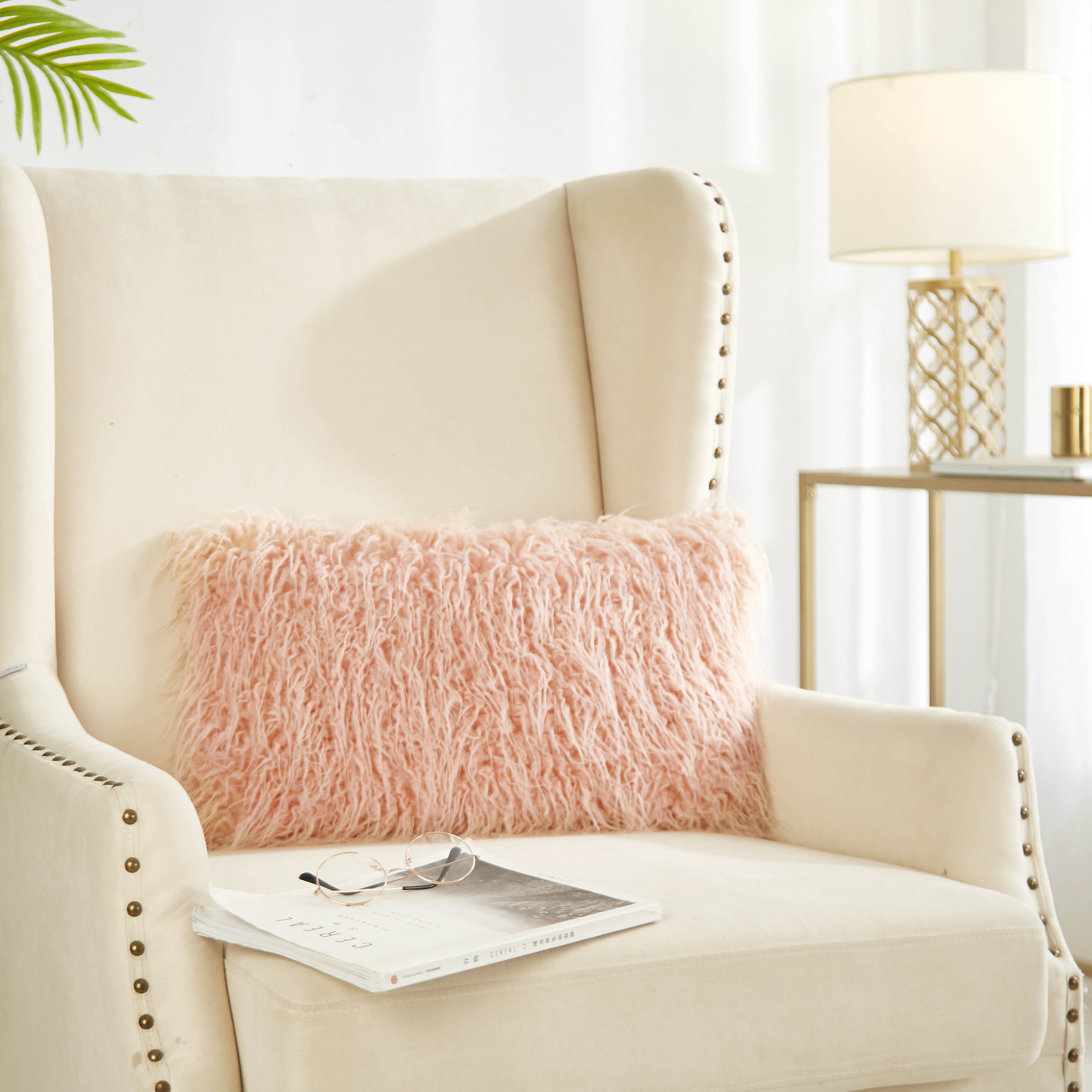 The pillow in pink on upholstered chair
