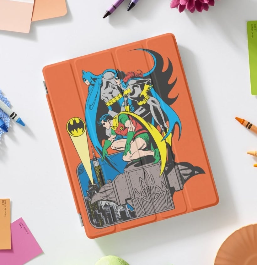 An orange iPad cover featuring artwrok of Batman, Batgirl, and Robin