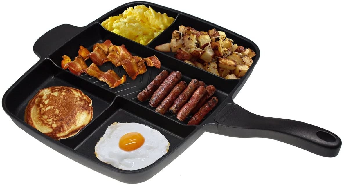 The skillet showing how many things it can cook at once, fitting scrambled eggs, potatoes, bacon, sausage, a pancake, and a fried egg into all of its compartments