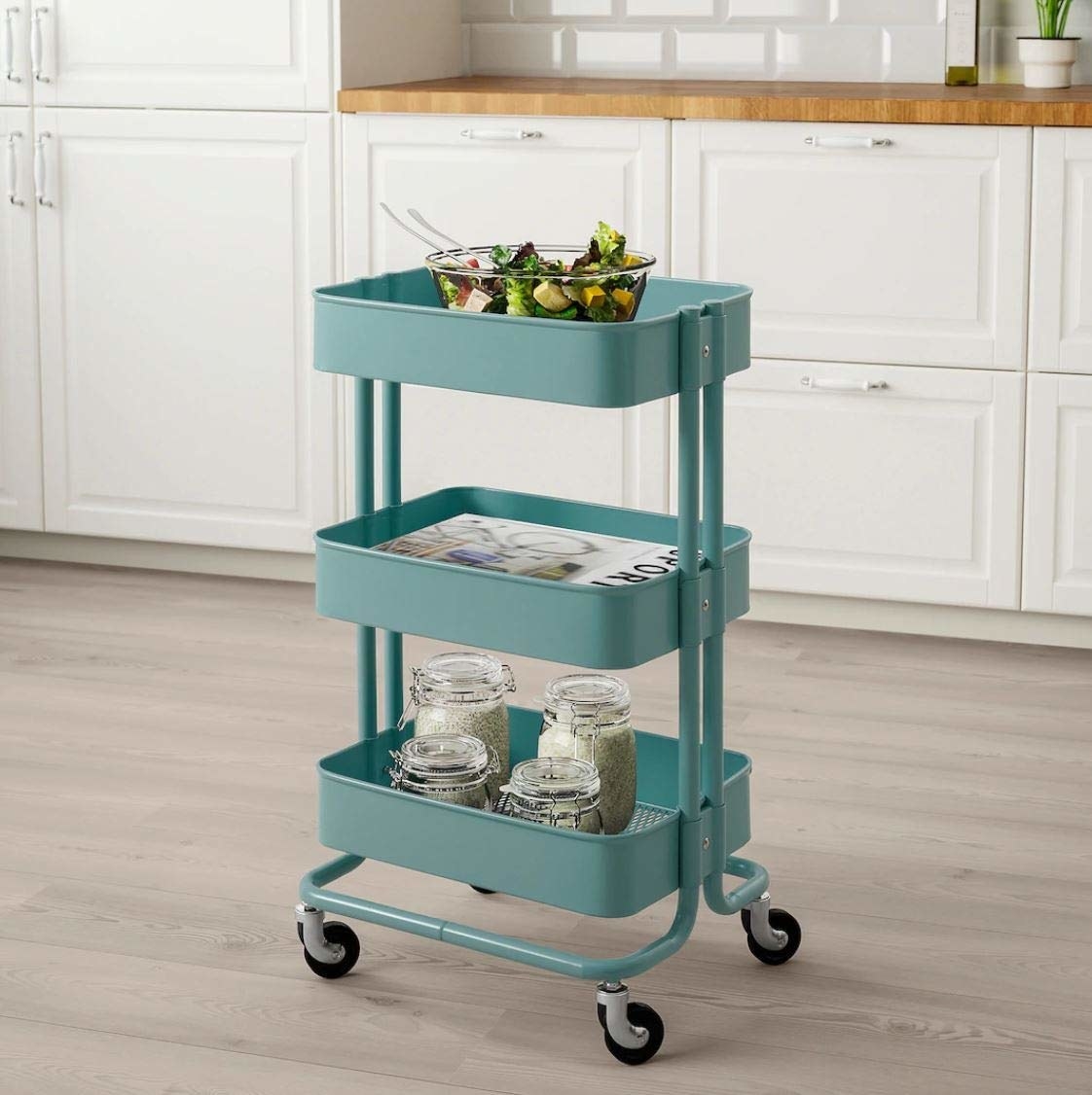 A teal utility cart with pantry products on it