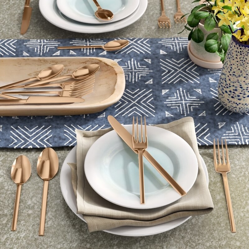 The flatware set laid out in a dinner spread in the gold color