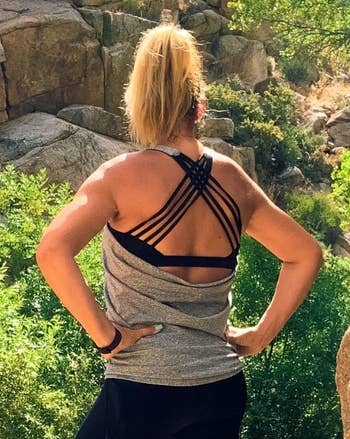 A different reviewer wearing the tank in grey, showing the back of the top with the strappy bra and low-cut back