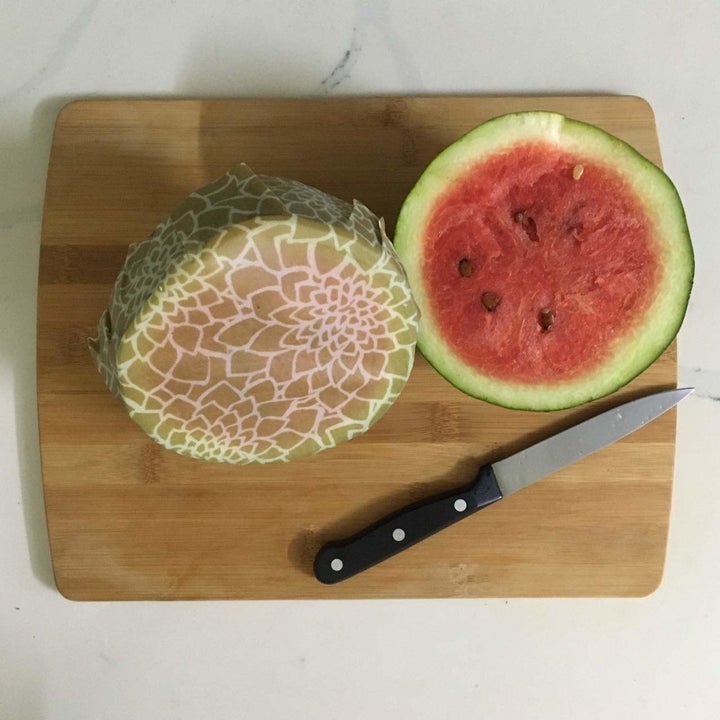 The beeswax wrap covering half a watermelon.