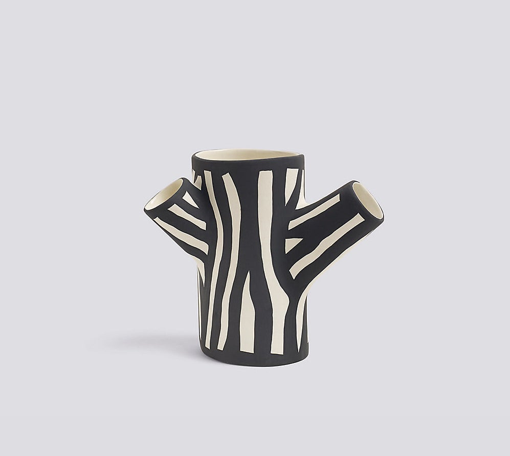 Black and white vase with three branches opening close to the trunk