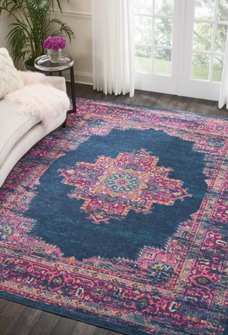 Pink and navy medallion patterned area rug in living room 