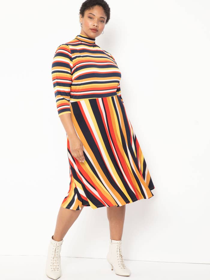 Model wearing plus-size striped knee-length dress with white boots
