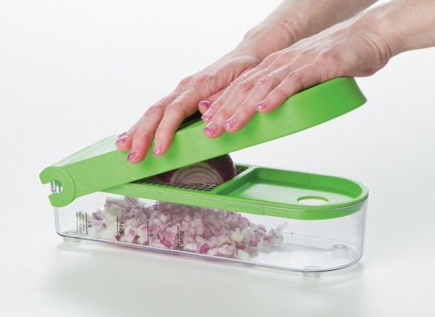 The slicer with an onion being pressed into it and diced