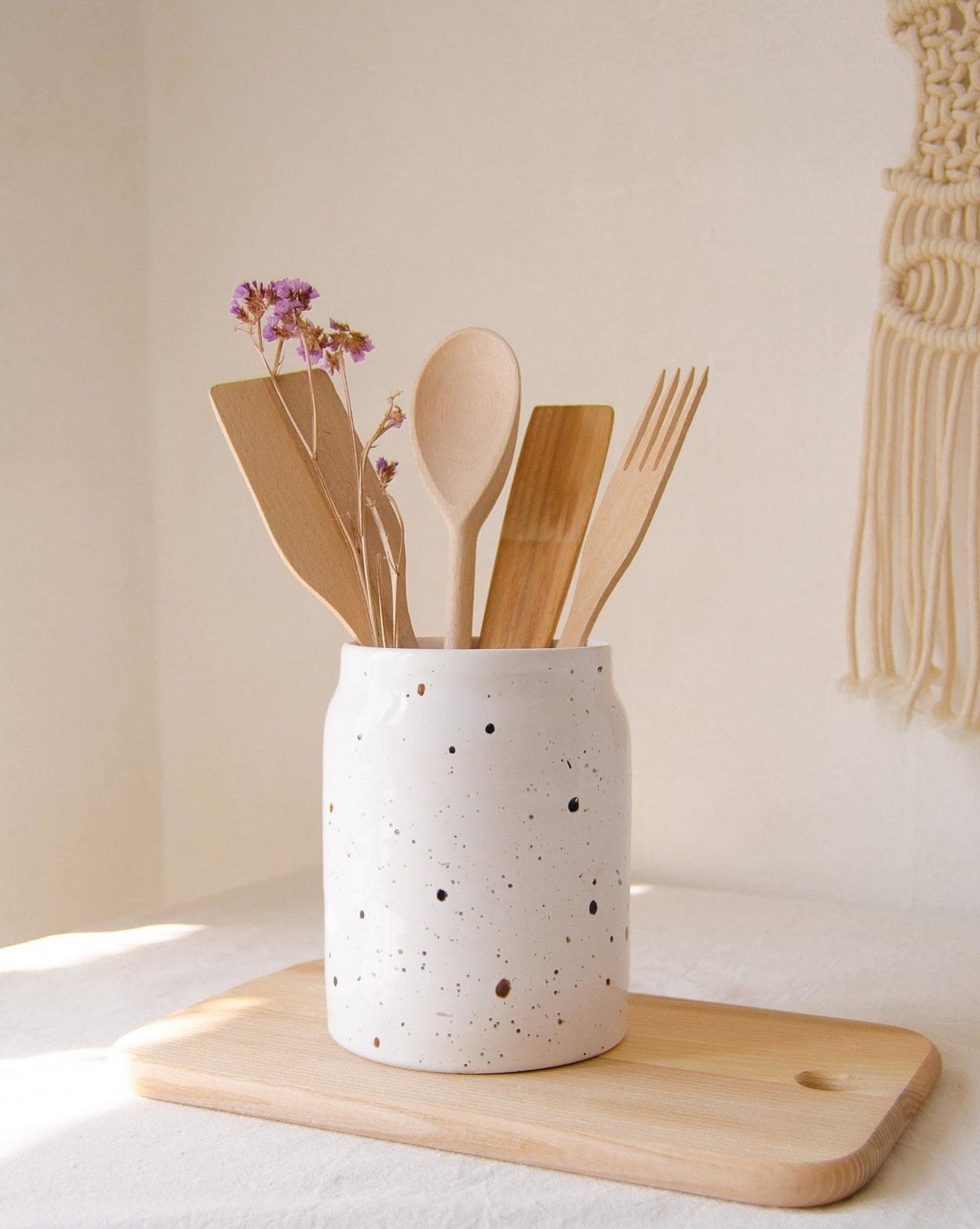 wooden utensils in a white speckled stoneware crock