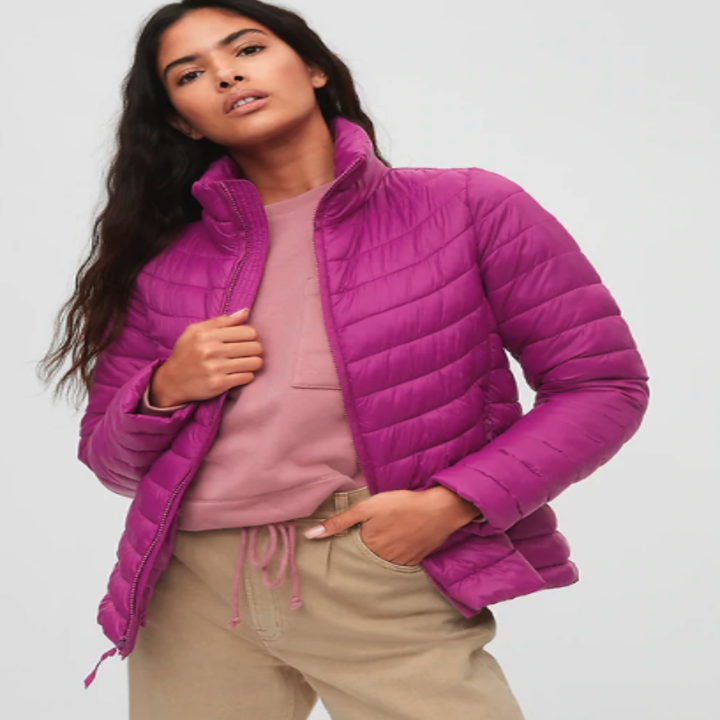 The pink puffer jacket has a neck-covering collar and the hem just hits the hips