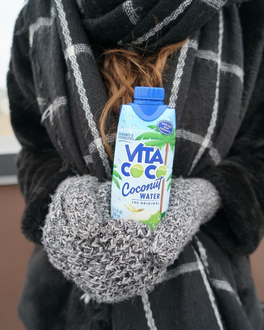 Model holds Vita Coco coconut water 