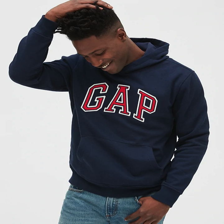 Male model wearing a navy hoodie with the word GAP written in red