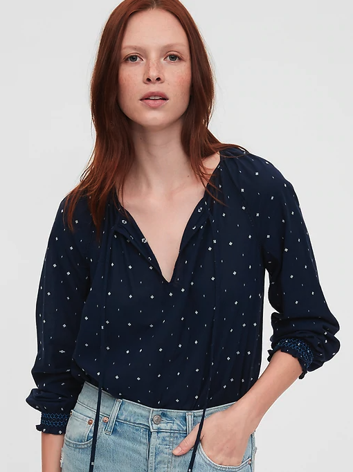 Model wearing the split-neck T-shirt, it has an open neckline and a diamond print