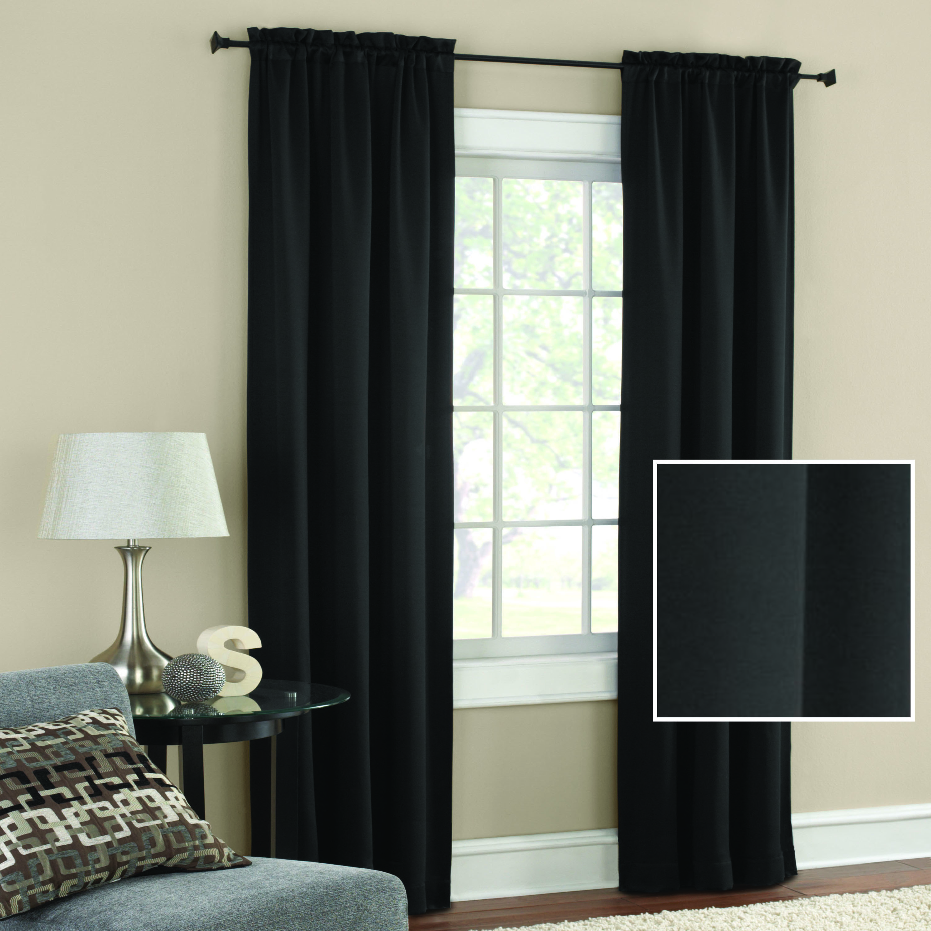 The black out curtains in black draped on a window