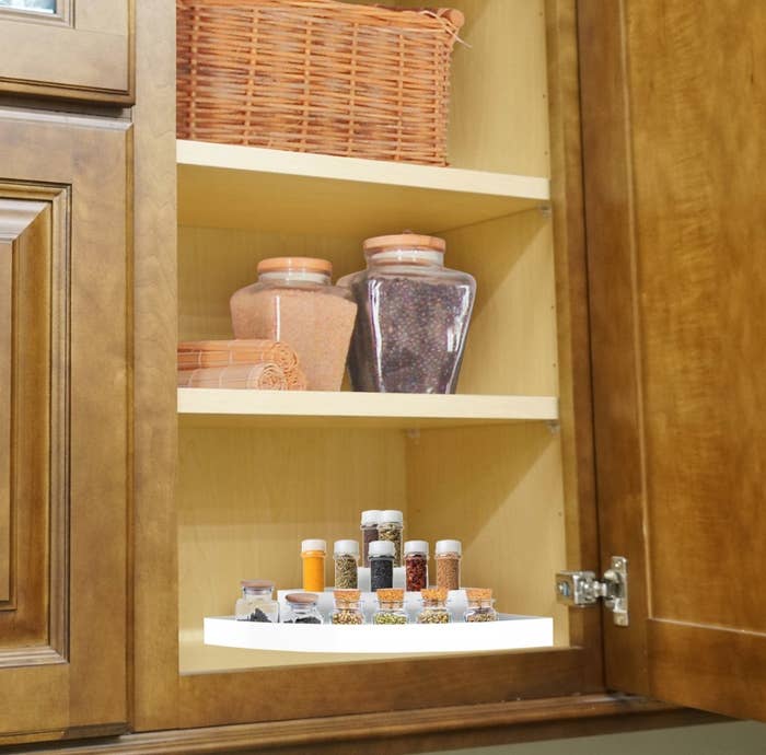 The organizer being used to hold spices in a cabinet