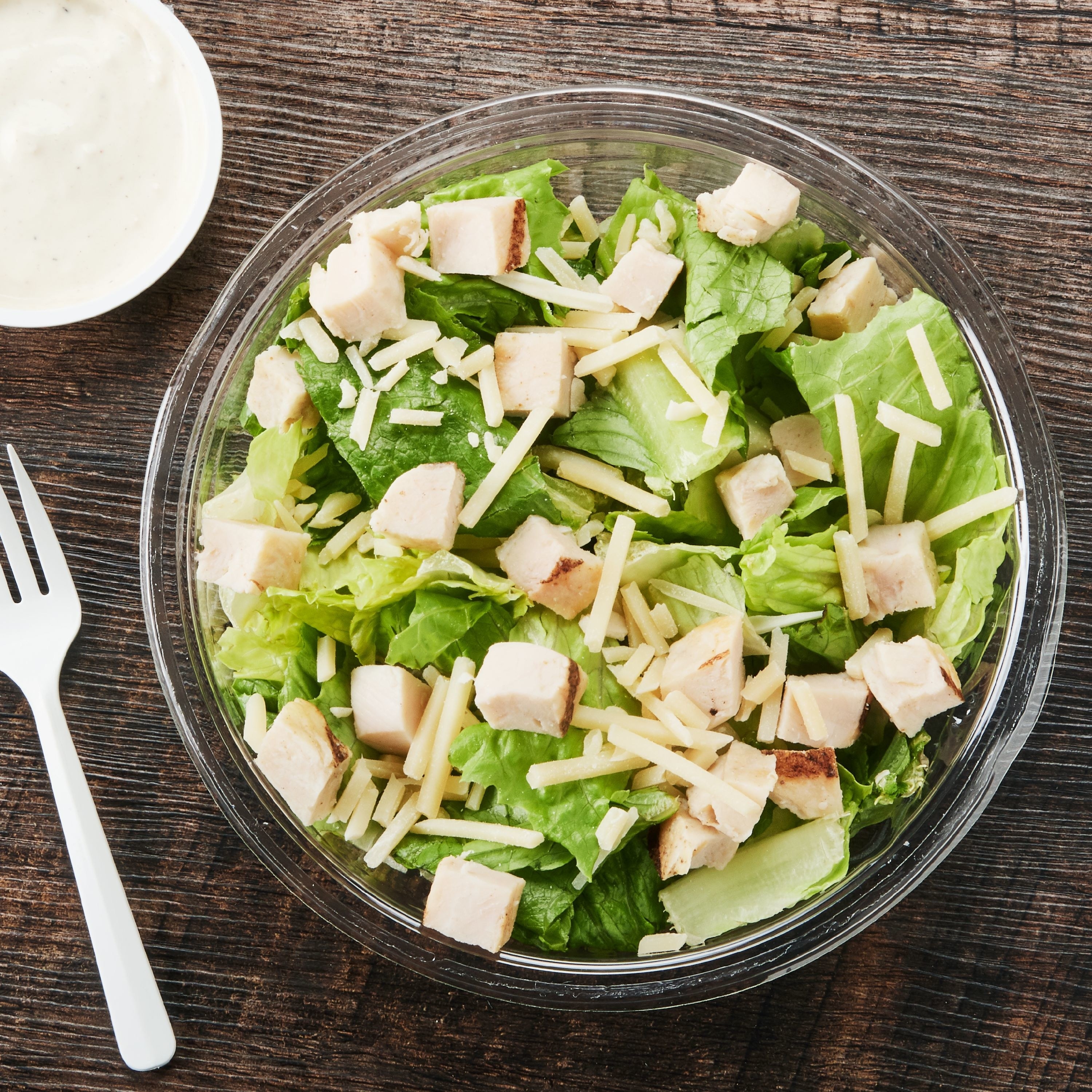 The Caesar salad tossed in a bowl