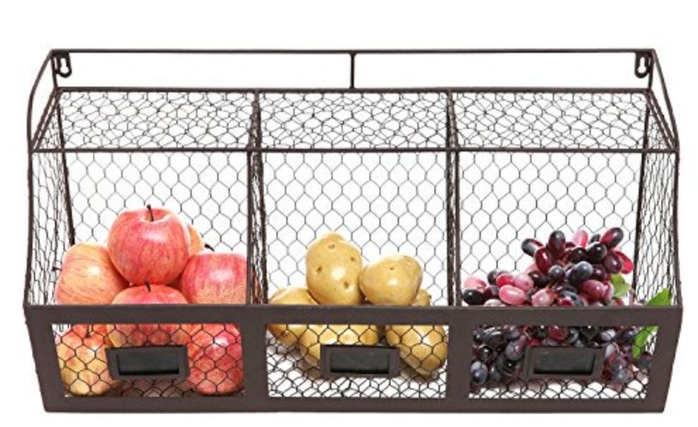The storage basket being used to hold apples, potatoes, and grapes