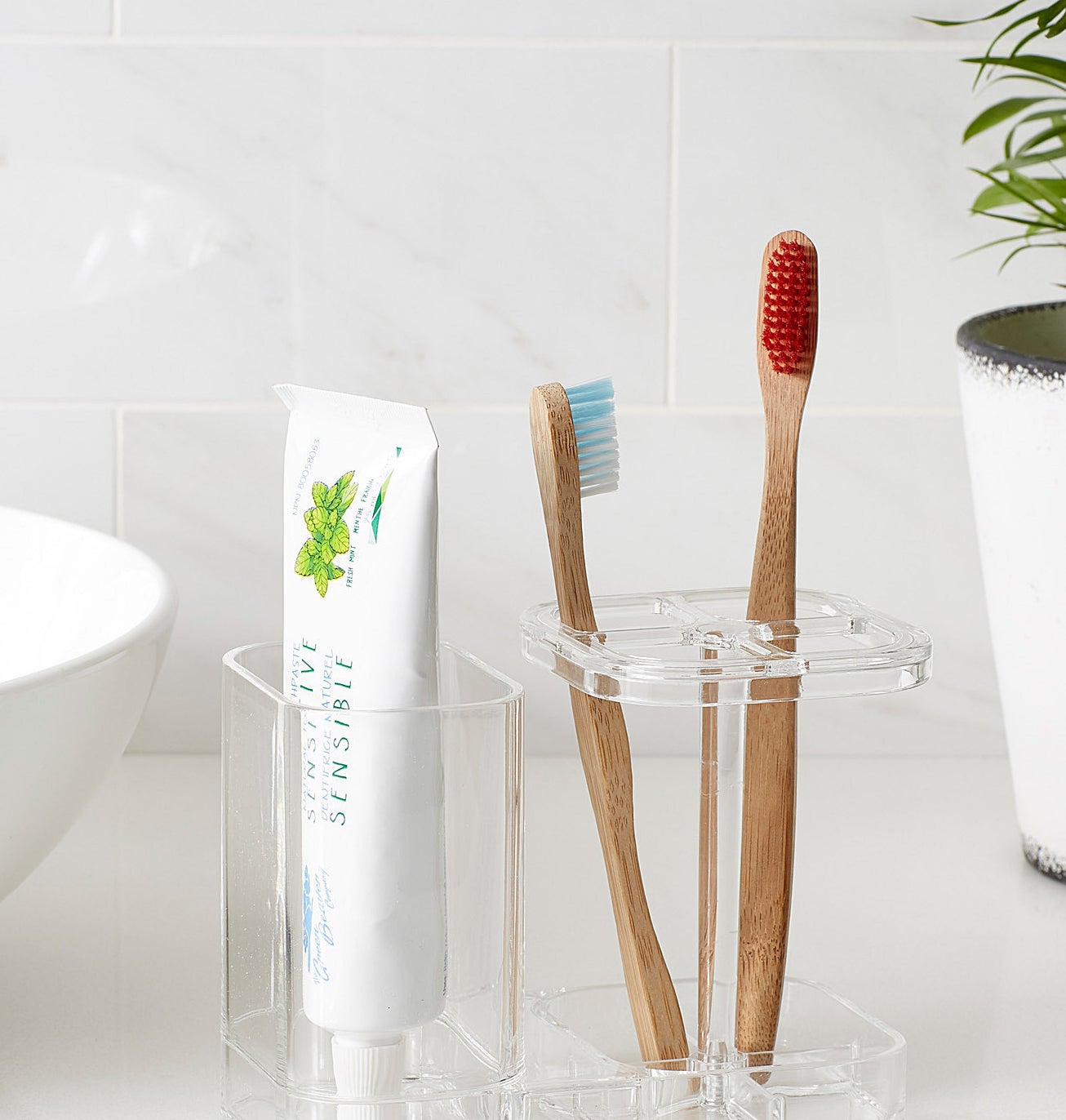 The bathroom organizer with toothbrushes and toothpaste inside of it