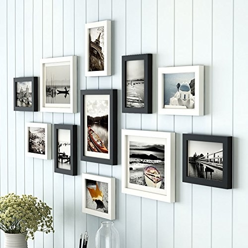 Black and white photo frames hung up on a white wall.